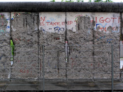 The Berlin wall. The wall has been so badly damaged by souvenir hunters that a fence now protects this once hated symbol of soviet oppression.
