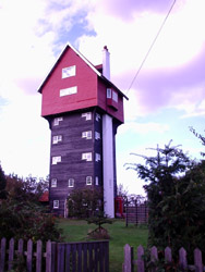 A weird holiday-house built around the water-tank associated with the windpump.